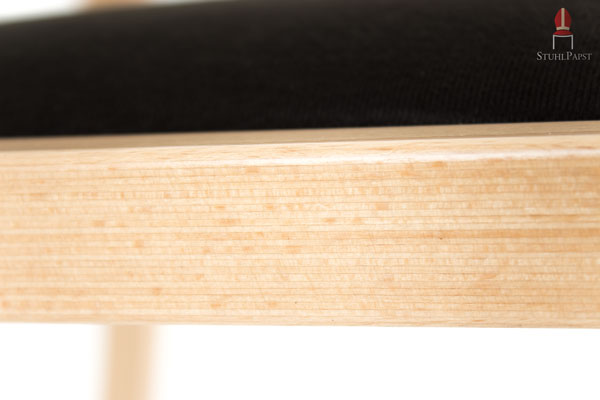 Der Armlehnenstuhl überzeugt durch eine Kombination aus Holz und Polstern